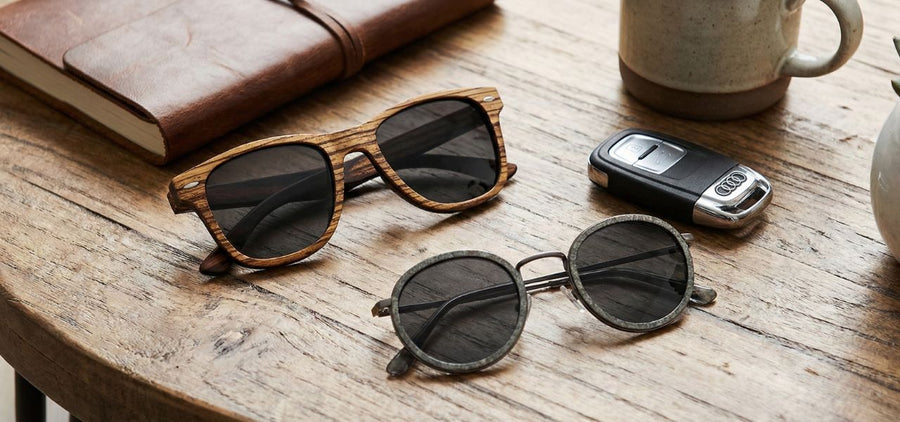 Wooden sunglasses with accessories on rustic surface